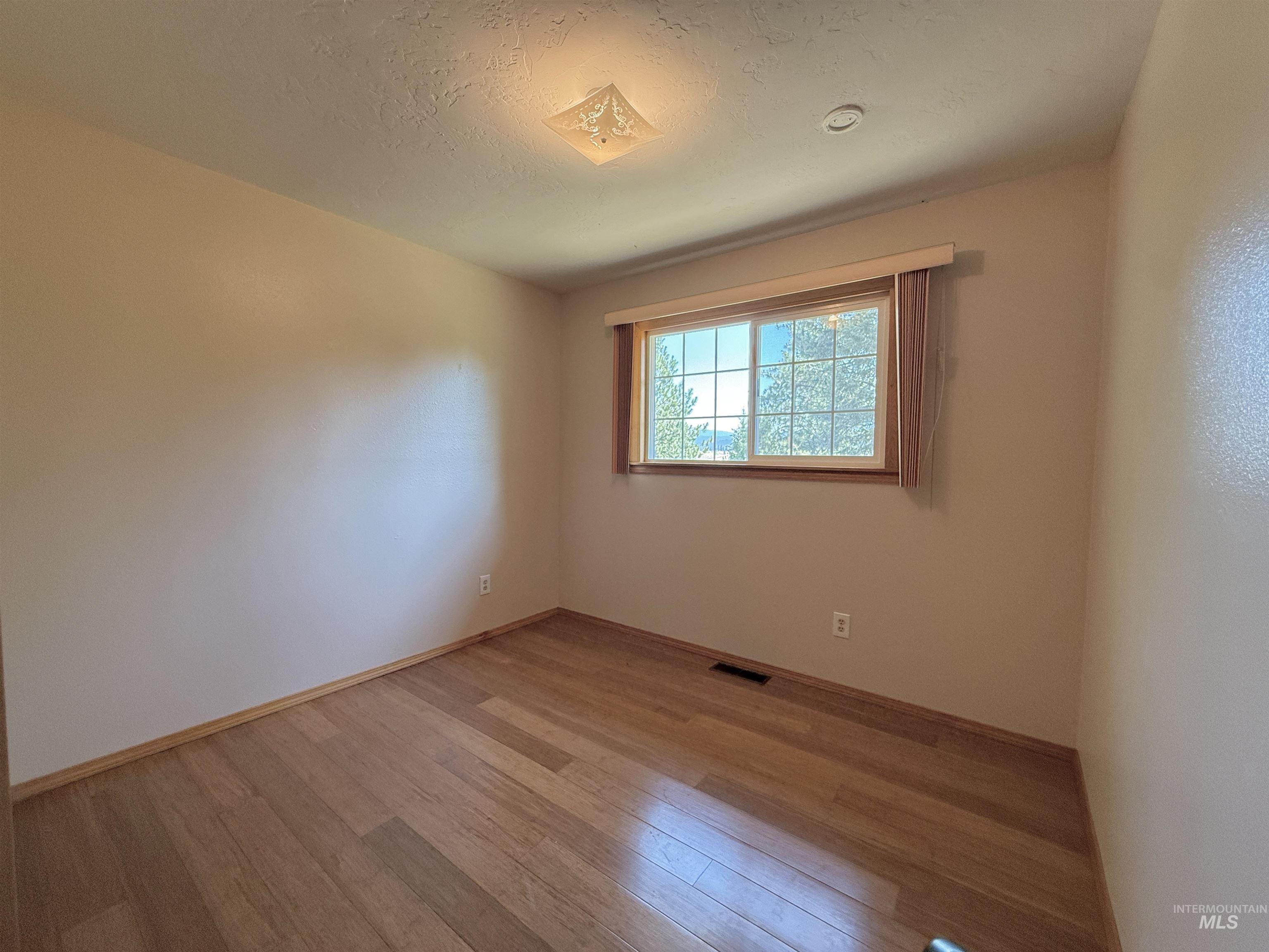 752 Mt Idaho Grade Road Grangeville, ID 83530 - Photo 9 of 29 Spare room featuring light wood-type flooring and a textured ceiling