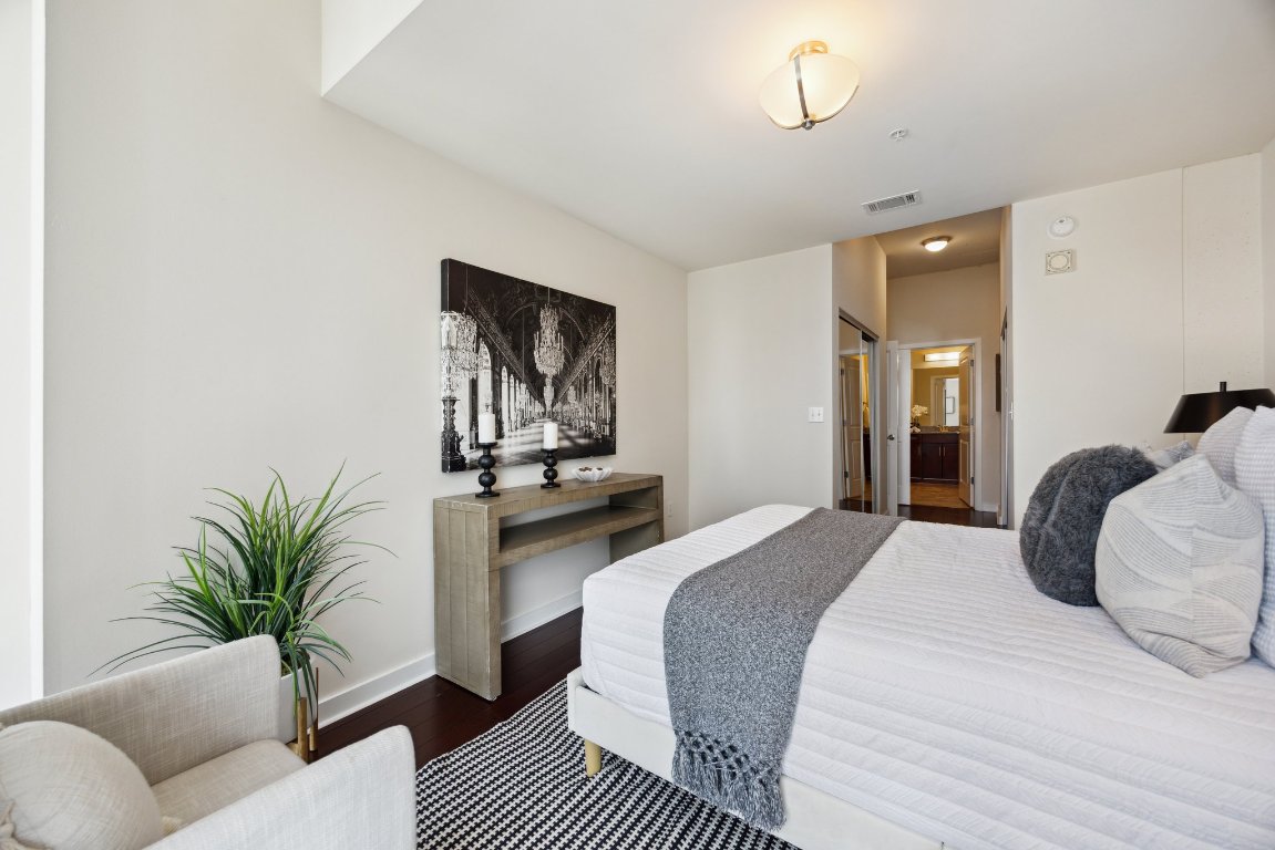 360 Nueces Street, Unit 1116 Austin, TX 78701 - Photo 17 of 33 a bedroom with a bed and ceiling fan