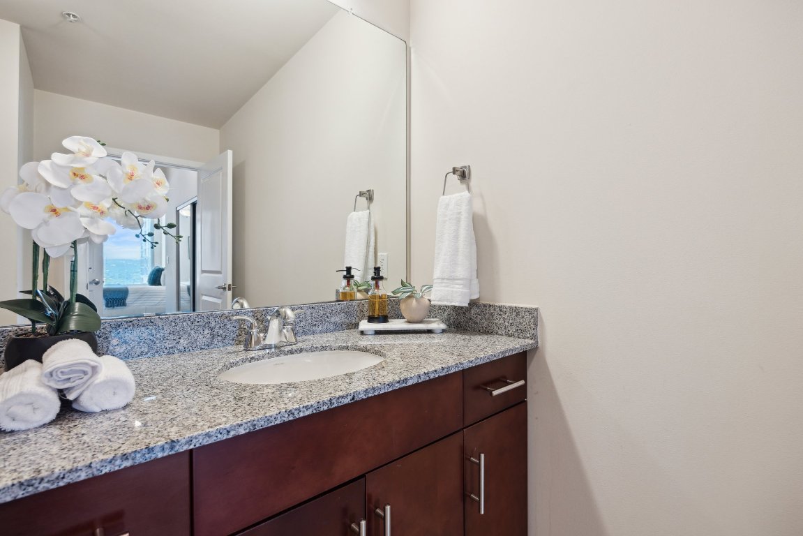 360 Nueces Street, Unit 1116 Austin, TX 78701 - Photo 19 of 33 a bathroom with a granite countertop sink and a mirror