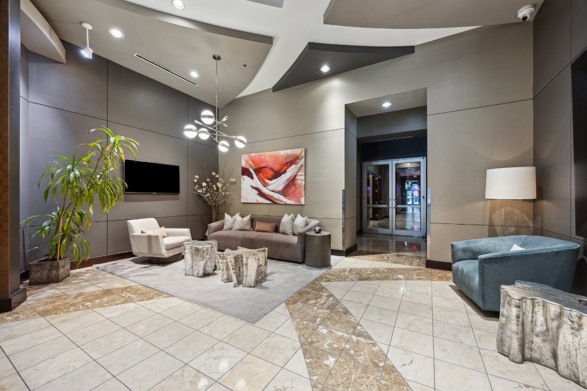 360 Nueces Street, Unit 1116 Austin, TX 78701 - Photo 32 of 33 a living room with furniture a flat screen tv and a chandelier
