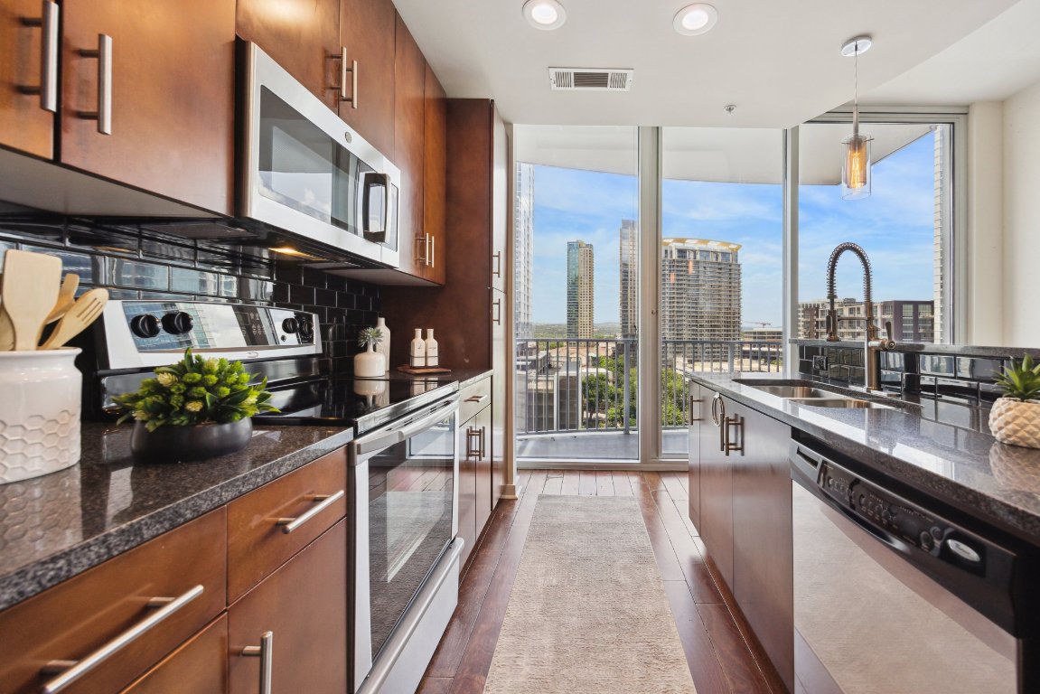 360 Nueces Street, Unit 1116 Austin, TX 78701 - Photo 5 of 33 a kitchen with stainless steel appliances a sink a counter top space cabinets and a potted plant