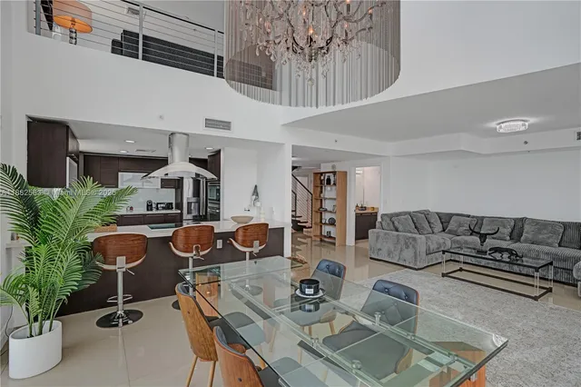 a living room with furniture a potted plant and a kitchen view