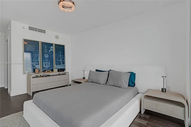 a bedroom with a large bed and a chandelier