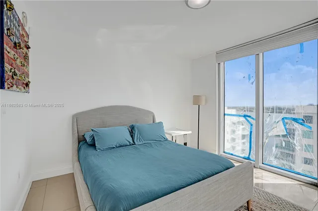 a bedroom with a large bed and a large window