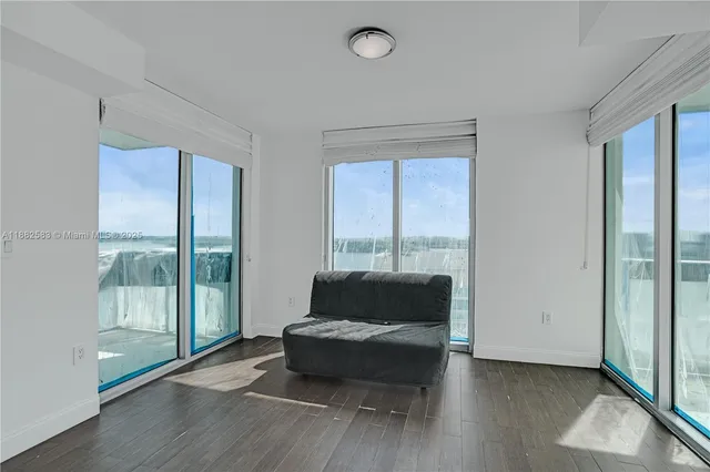 a living room with furniture and a floor to ceiling window