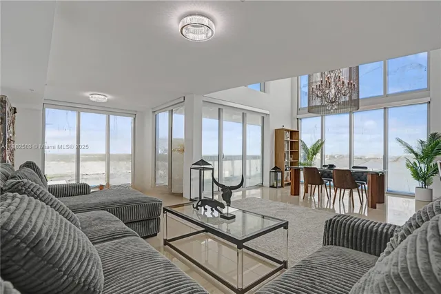 a living room with furniture and floor to ceiling windows