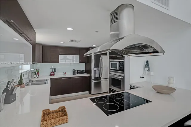 a kitchen with stainless steel appliances a stove a sink and a refrigerator