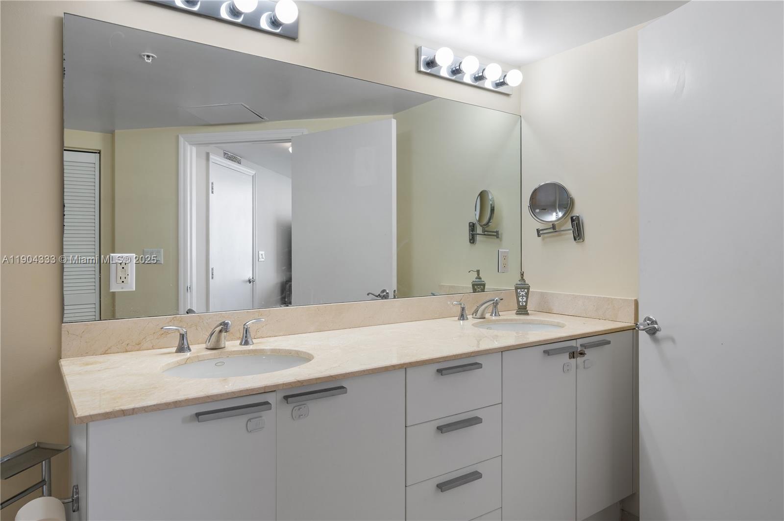 16699 Collins Avenue, Unit 3305 Sunny Isles Beach, FL 33160 - Photo 17 of 20 a bathroom with a sink and a mirror