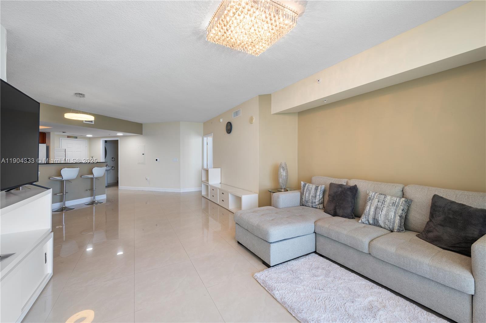 16699 Collins Avenue, Unit 3305 Sunny Isles Beach, FL 33160 - Photo 6 of 20 a living room with furniture and a couch