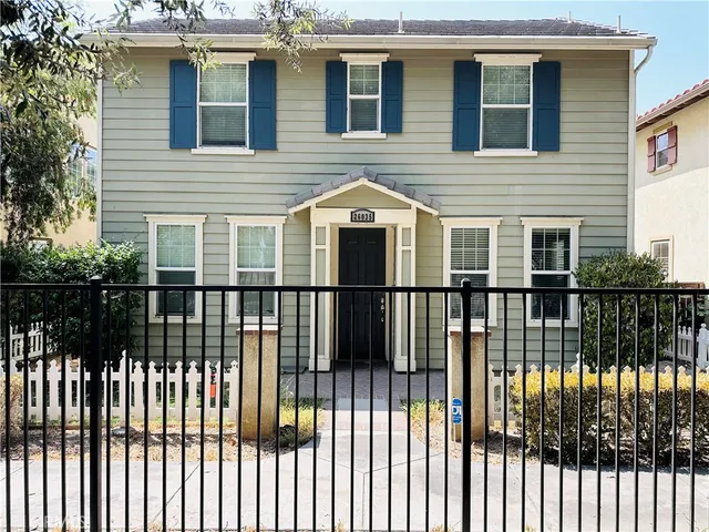 a front view of a house with a iron gate