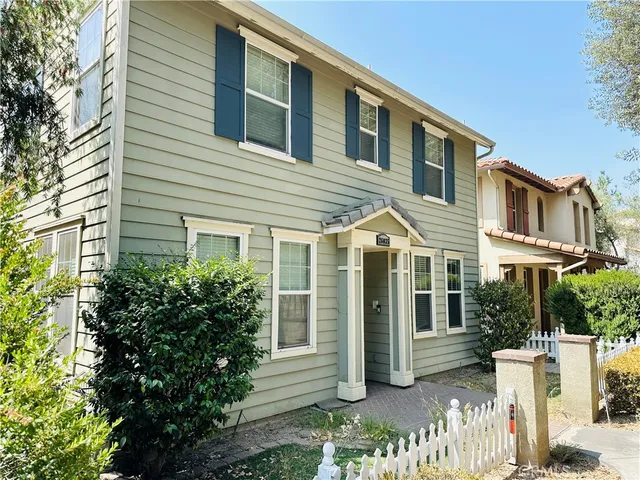 a view of a white house next to a yard