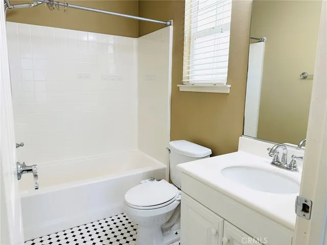 a bathroom with a granite countertop sink toilet and a mirror