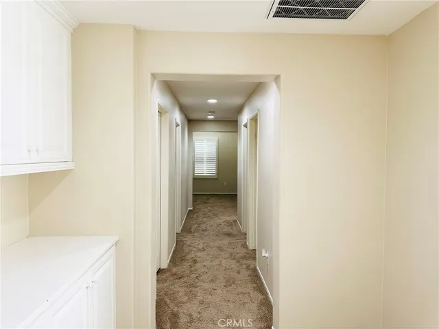 a picture of a brick house with wooden floor and fence