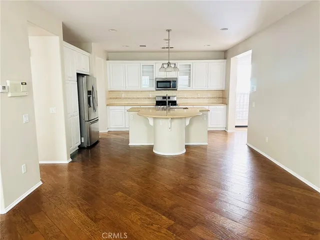 a view of kitchen with stainless steel appliances refrigerator stove microwave and cabinets