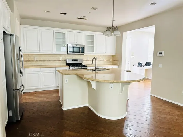 a kitchen with kitchen island a stove a sink and a refrigerator
