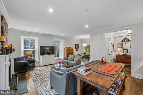 a living room with furniture a flat screen tv and kitchen view