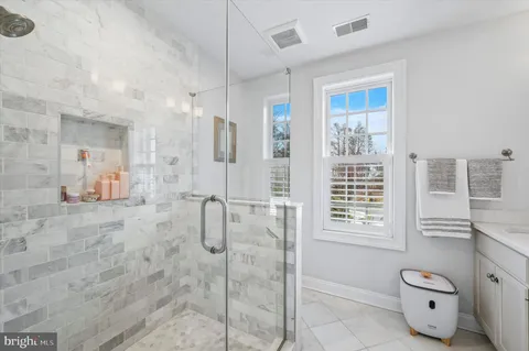 a bathroom with a granite countertop sink a mirror and a shower