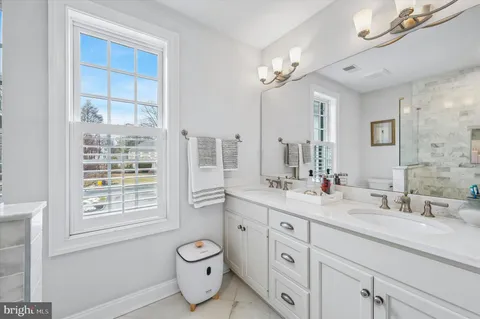 a bath room with a sink a vanity and a large mirror