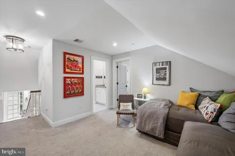 a living room with furniture and a painting on the wall