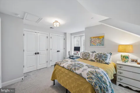 a bedroom with a bed and a painting on the wall