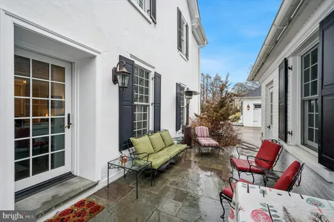 a backyard of a house with sofas table and chairs