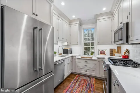 a kitchen with white cabinets and stainless steel appliances