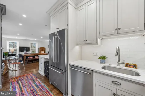 a kitchen with a sink stainless steel appliances and white cabinets