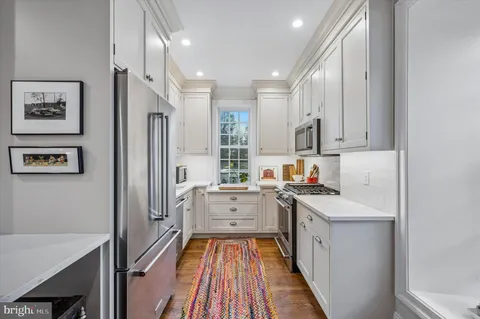a kitchen with stainless steel appliances a stove refrigerator sink and cabinets