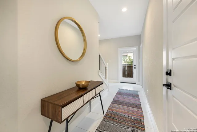 a kitchen with stainless steel appliances kitchen island granite countertop a refrigerator a stove a sink a dining table and chairs with wooden floor