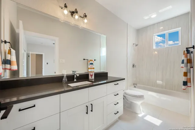 a living room with furniture a potted plant and kitchen view