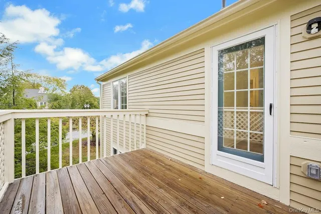 a view of a wooden balcony with a floor to ceiling window