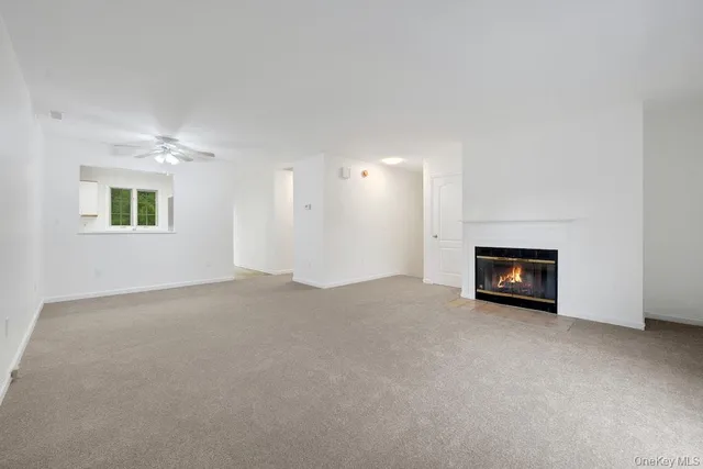 a view of an empty room with a fireplace and a window