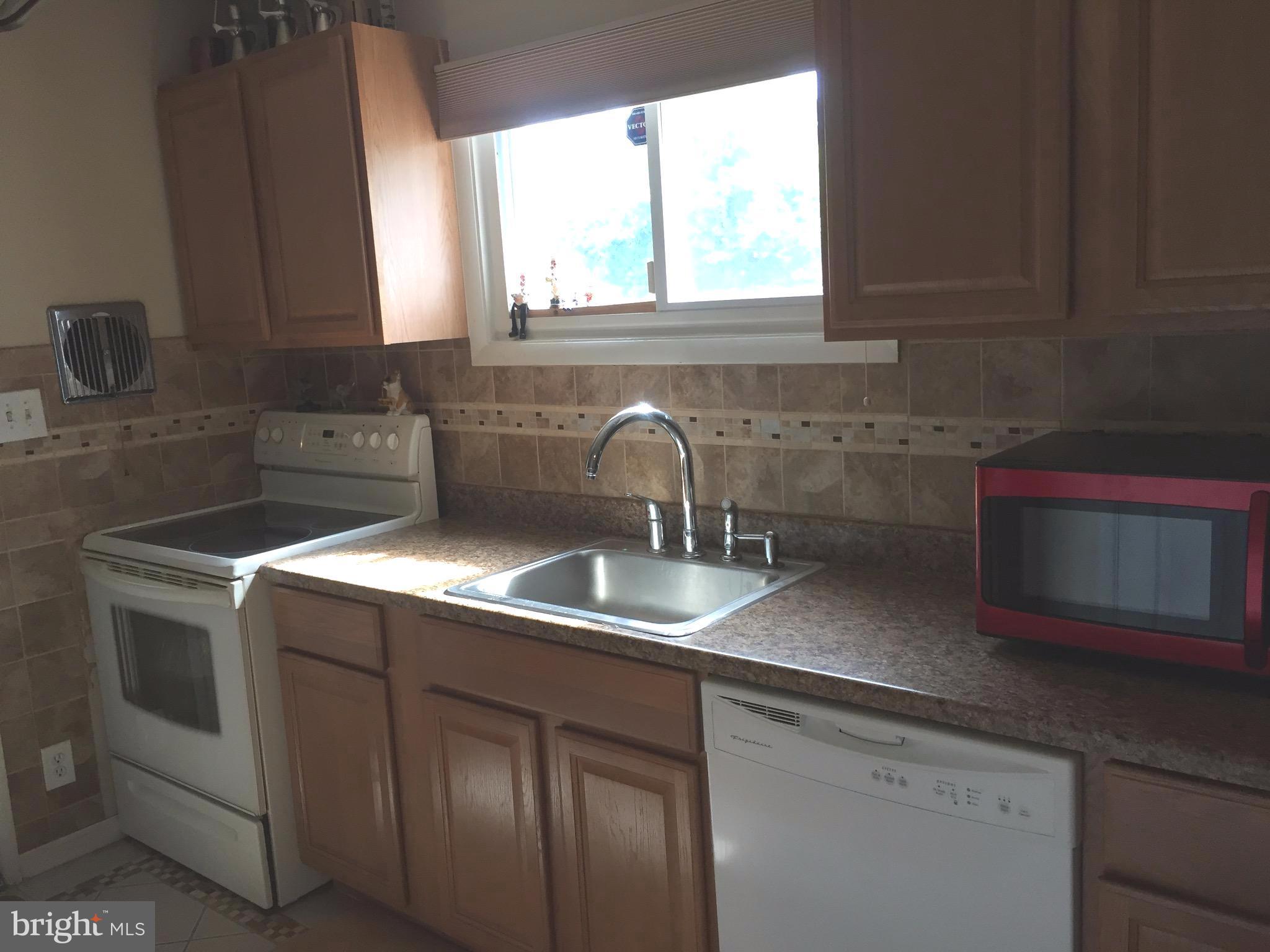 5931 Robindale Road Baltimore, MD 21228 - Photo 3 of 12 a kitchen with a sink cabinets and window