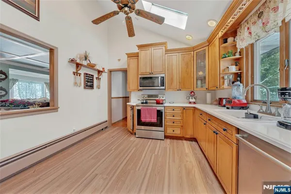 a kitchen with stainless steel appliances a stove top oven a sink a counter space and cabinets