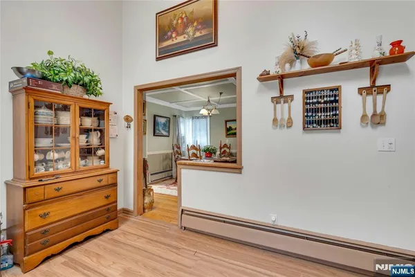 a view of a hallway with wooden floor and paintings on the wall