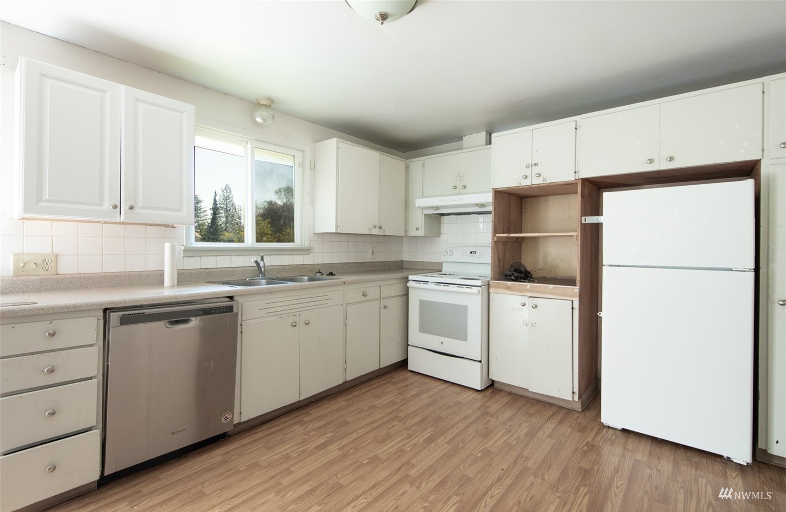 11919 East Gibson Road Everett, WA 98204 - Photo 12 of 27 a kitchen with a refrigerator sink and white cabinets