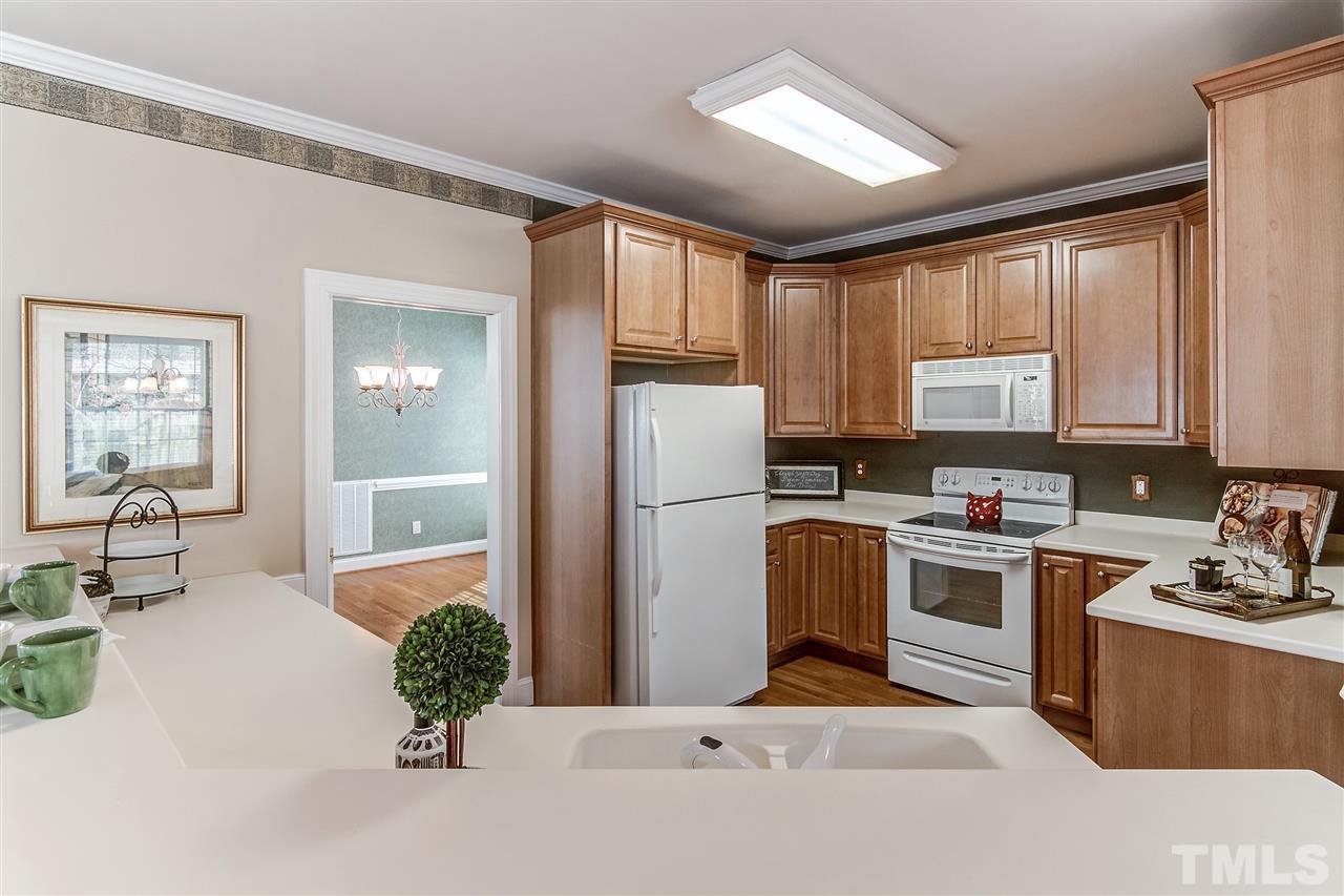 2401 Carruthers Court Raleigh, NC 27615 - Photo 9 of 25 a kitchen with a refrigerator and a stove top oven