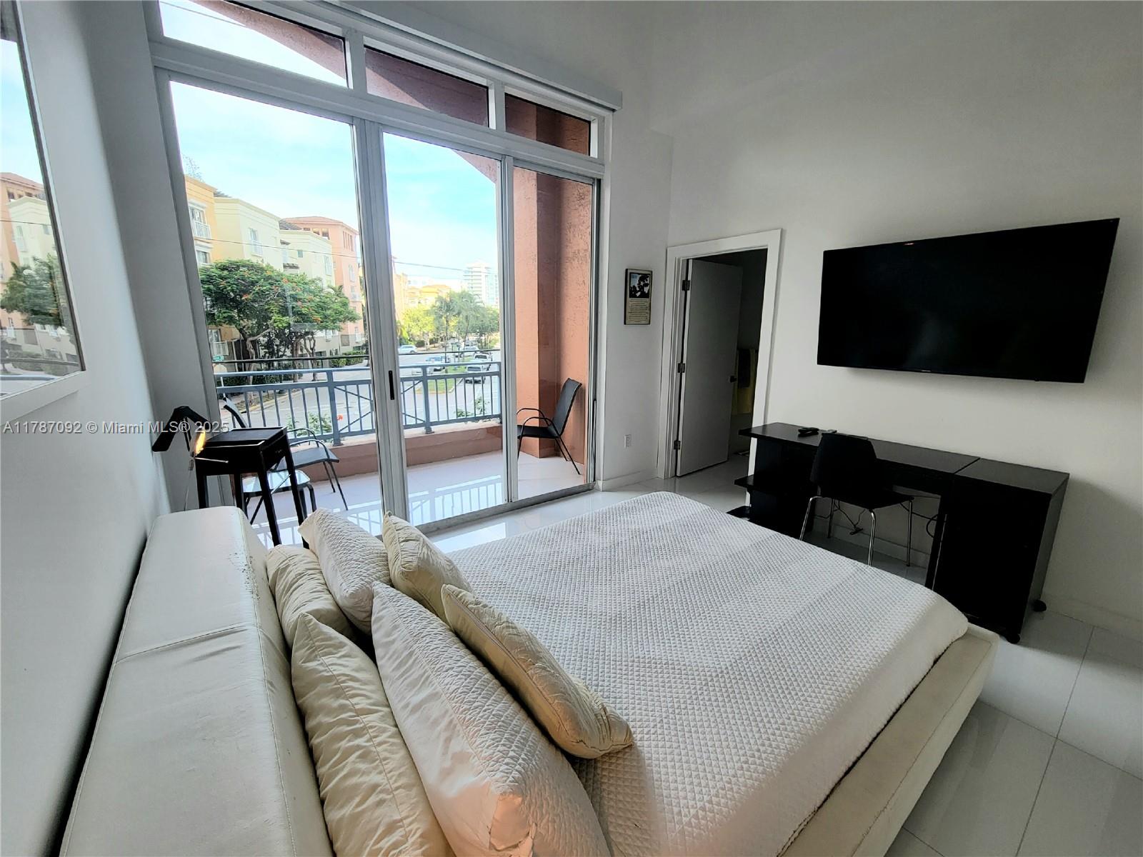 90 Alton Road, Unit 1 Miami Beach, FL 33139 - Photo 14 of 36 a living room with a bed and a flat screen tv