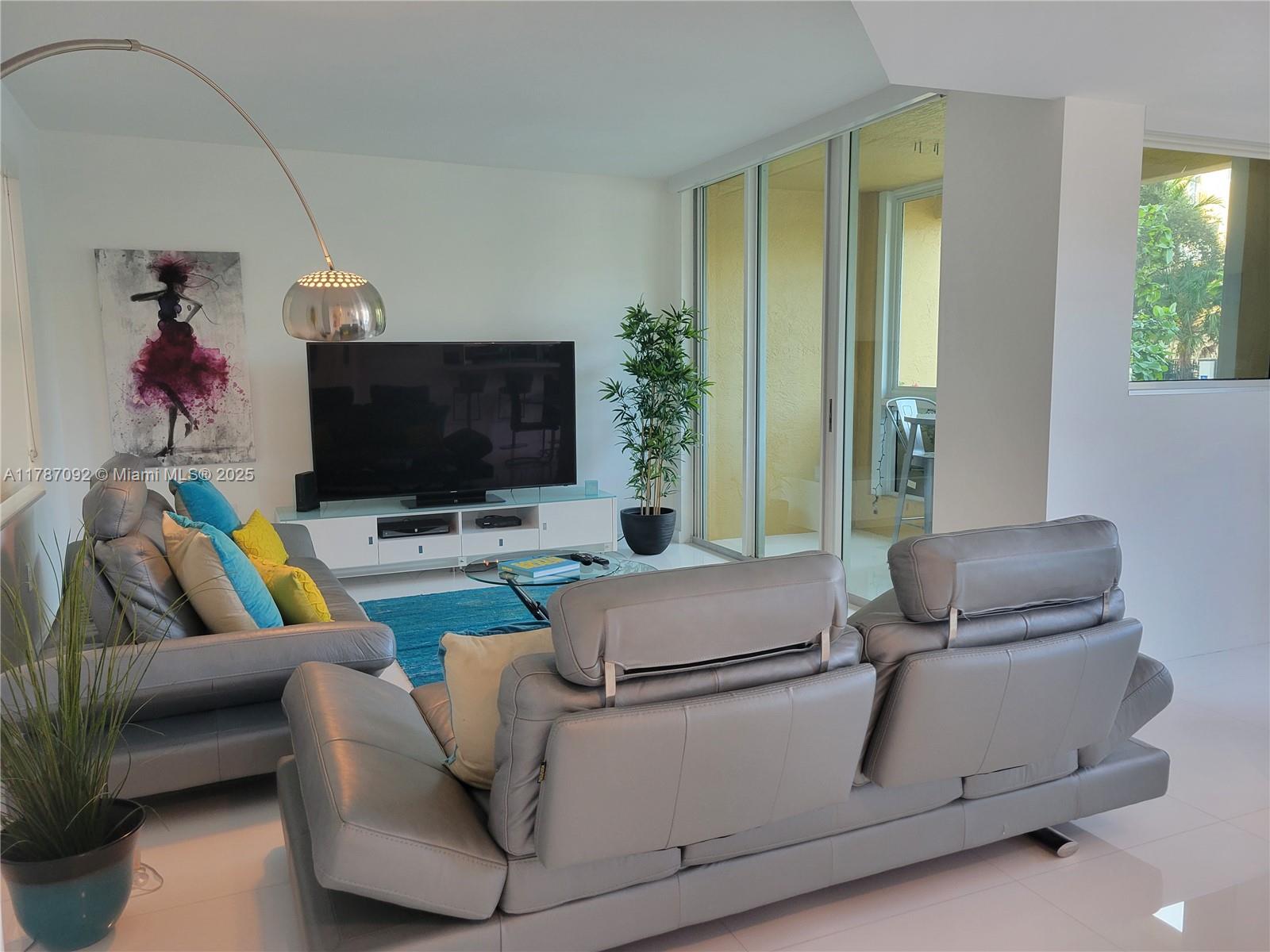 90 Alton Road, Unit 1 Miami Beach, FL 33139 - Photo 4 of 36 a living room with furniture and a flat screen tv