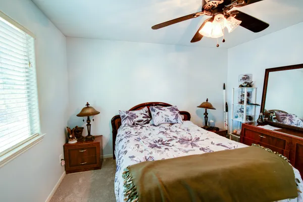 a bed sitting in a bedroom next to a window
