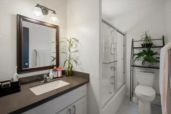 a bathroom with a granite countertop sink toilet and shower