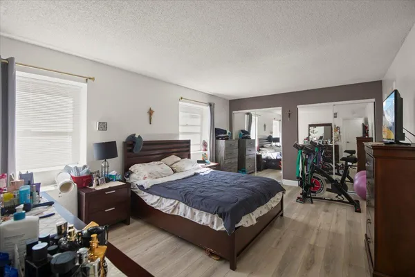 a bedroom with a bed a dresser and a window