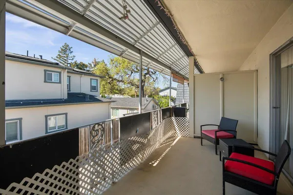 a view of a balcony with furniture and a potted plant