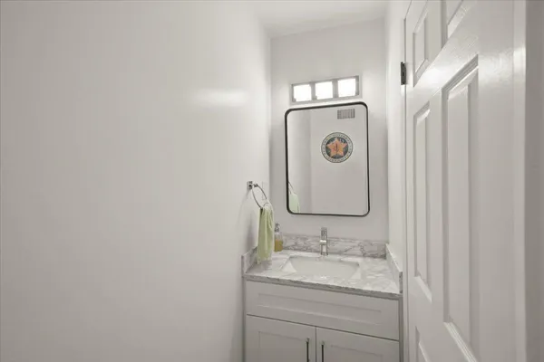 a bathroom with a granite countertop sink and a mirror
