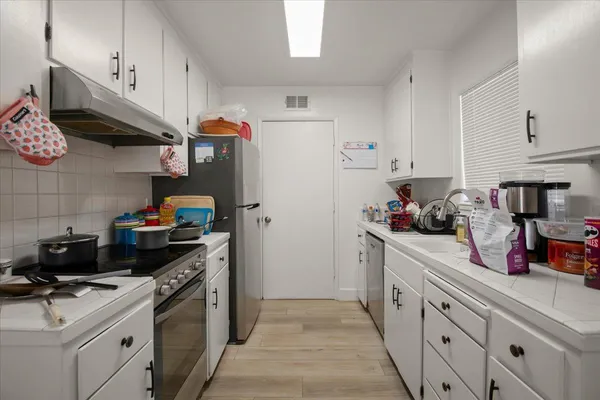 a kitchen with stainless steel appliances a sink dishwasher stove and refrigerator