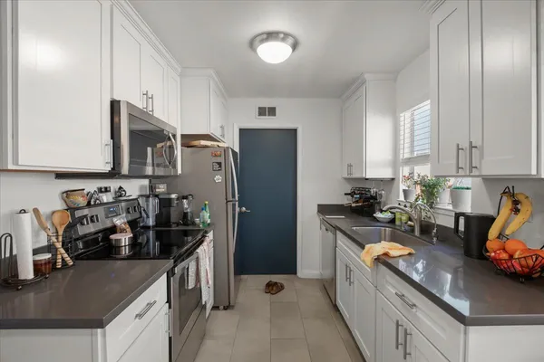 a kitchen with refrigerator a stove and a sink