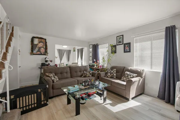 a living room with furniture and a window with wooden floor