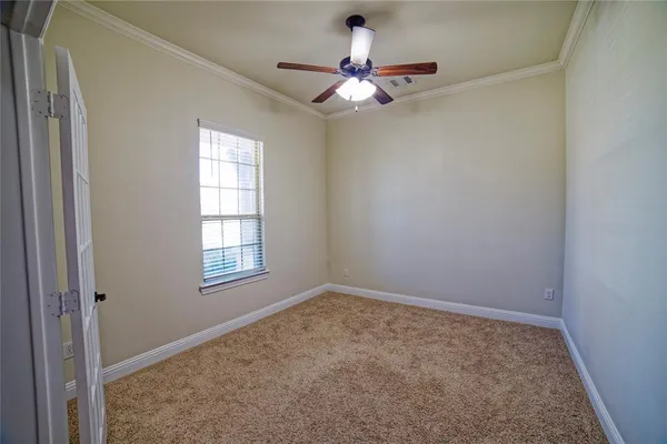 an empty room with a window and a fan