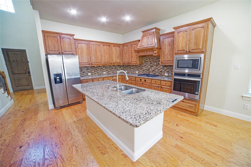 10929 Calvert Place McKinney, TX 75071 - Photo 14 of 39 a kitchen with stainless steel appliances granite countertop a sink stove and refrigerator