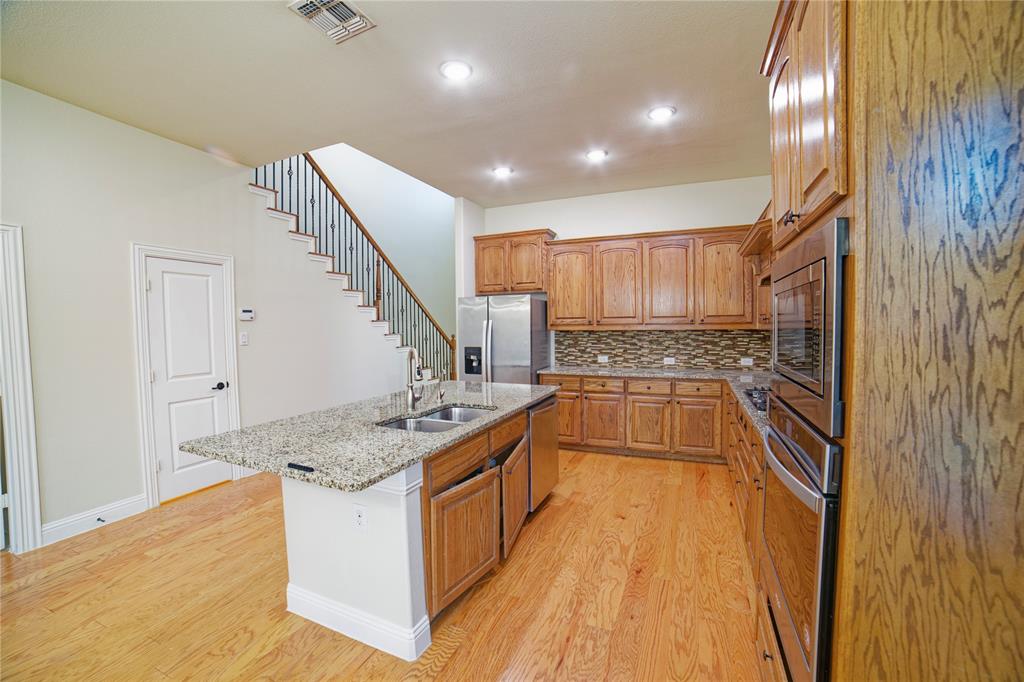 10929 Calvert Place McKinney, TX 75071 - Photo 15 of 39 a kitchen with stainless steel appliances granite countertop a stove and a refrigerator